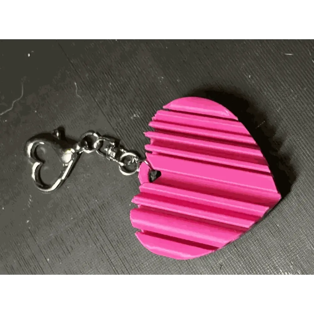 Custom 3D-printed heart-shaped keychain in pink with ribbed texture.